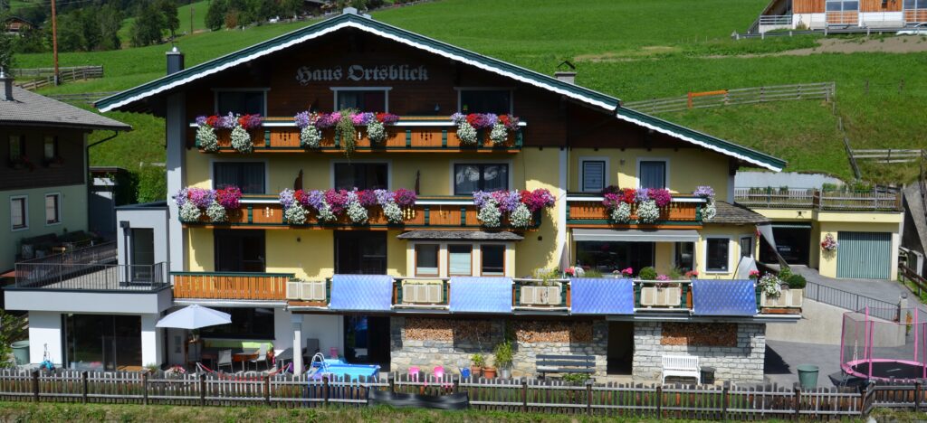Ein charmantes Gebäude mit großzügigen Balkonen und einem schönen Ausblick auf die grünen Hügel. Die Umgebung ist malerisch und einladend. Deutsch: Das Haus Ortsblick mit seinen vier Appartements in Wagrain.
English: A charming building with spacious balconies and a beautiful view of the green hills. The surroundings are picturesque and inviting. The house Ortsblick with its four apartments in Wagrain.
