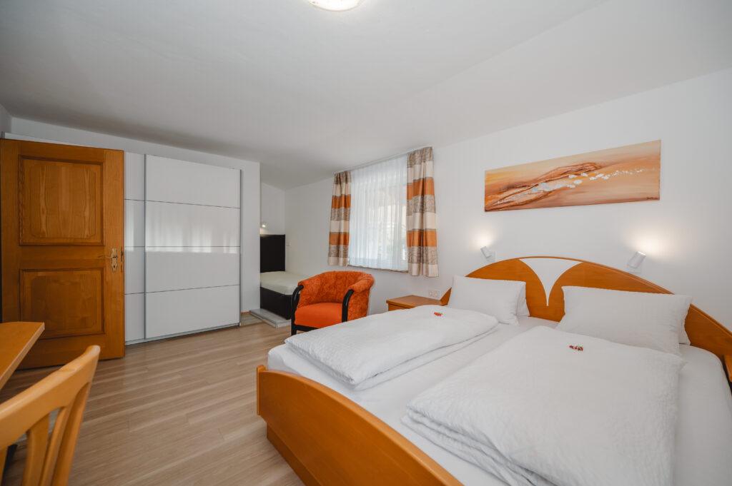 Appartement Grafenberg 1 - Schlafraum 2 mit Doppelbett, zusätzlichen Einzelbett, Flat TV und Balkon mit Blick auf Wagrain