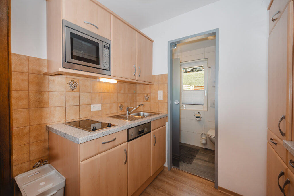 Appartement Edelweiß 1 - Vollausgestattete neue Küche mit Ofen, Mikrowelle, Kaffeemaschine, Geschirrspüler und Küchenutelsilien. Mit Essecke, Zusatzcouch und Flat TV