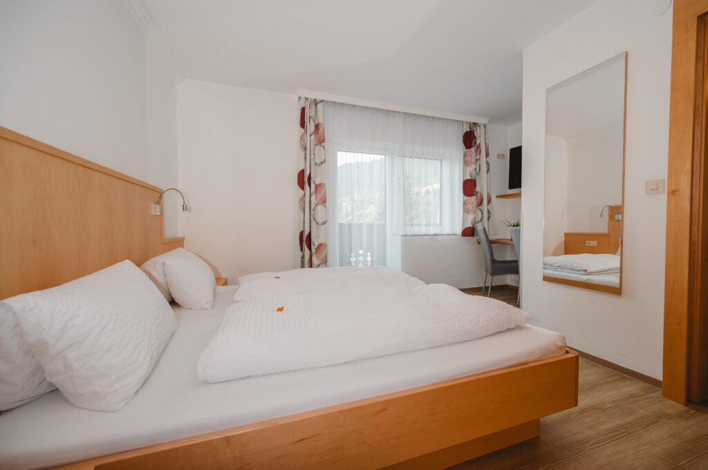 Appartement Edelweiß 1 - Schlafraum 1 mit Doppelbett und eigene Dusche / WC. Flat TV und Balkon mit Blick auf Wagrain