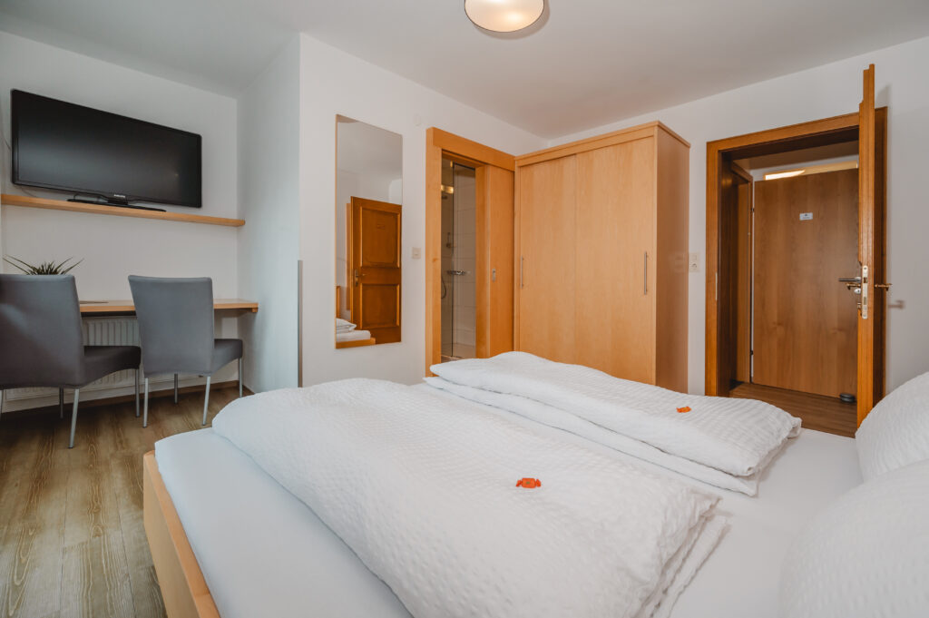 Appartement Edelweiß 1 - Schlafraum 1 mit Doppelbett und eigene Dusche / WC. Flat TV und Balkon mit Blick auf Wagrain