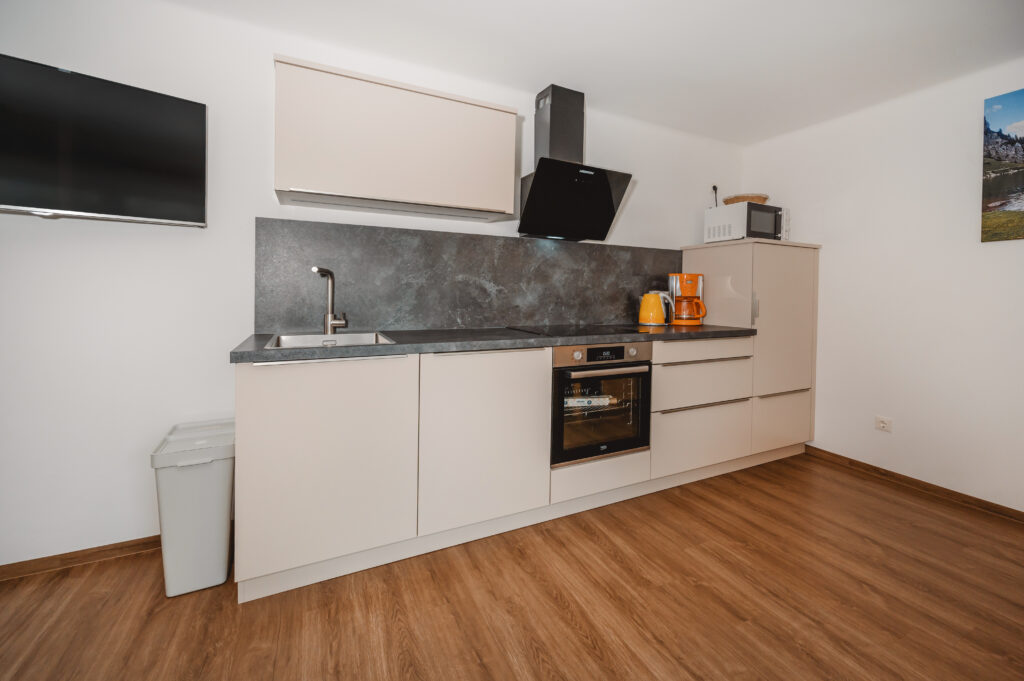 Appartement Grafenberg 2 - Vollausgestattete neue Küche mit Ofen, Mikrowelle, Kaffeemaschine, Geschirrspüler und Küchenutelsilien. Mit Essecke, Zusatzcouch und Flat TV