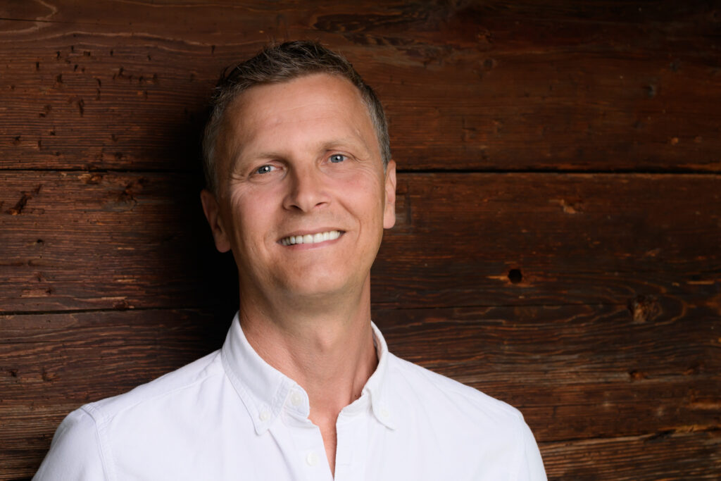 Deutsch: Juniorchef Peter Oberweger Haus Ortsblick lächelt an Holzwand gelehnt
English: Junior manager Peter Oberweger Haus Ortsblick smiles leaning against a wooden wall
