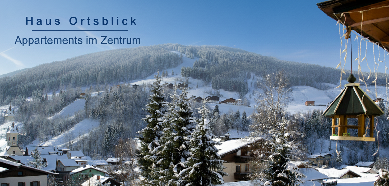 Deutsch: Schneebedecktes Dorf und Tannen vor Bergkulisse, blauer Himmel und ein dekoratives Vogelhäuschen im Vordergrund. Der Text lautet „Haus Ortsblick Appartements im Zentrum“. English: Snowy mountain village with scattered houses, evergreen trees, and a hanging birdhouse in the foreground; text advertises central apartments at Haus Ortsblick.