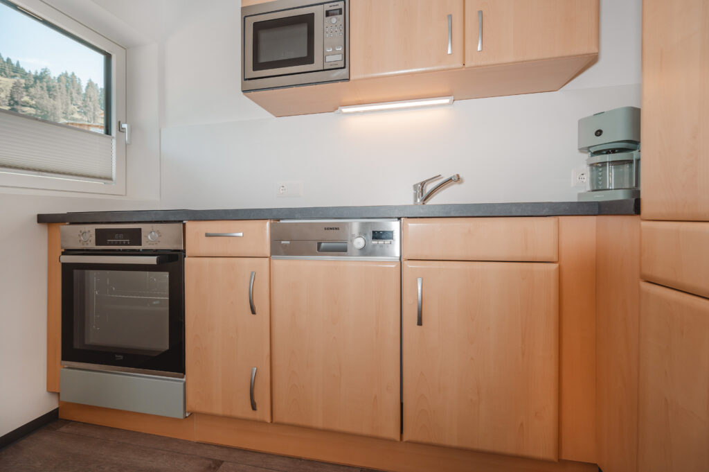 Appartement Edelweiß 2 - Vollausgestattete Küche mit Ofen, Mikrowelle, Kaffeemaschine, Geschirrspüler und Küchenutelsilien.